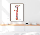 Framed artwork of a colorful otoscope on a white wall above a wooden shelf.
